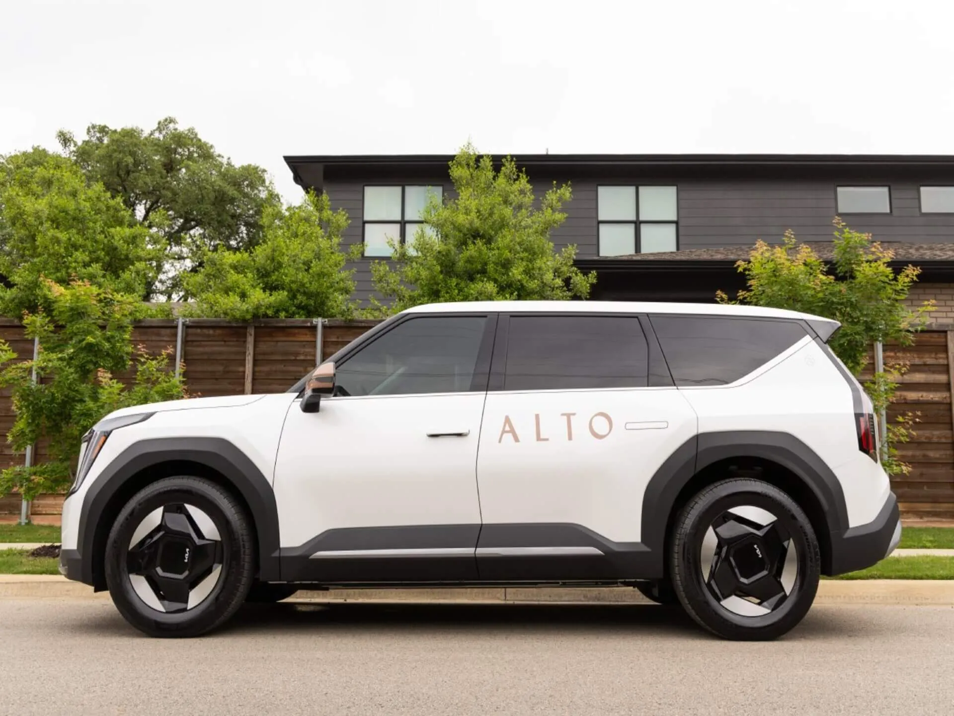 A white Alto-branded SUV parked beside a building.