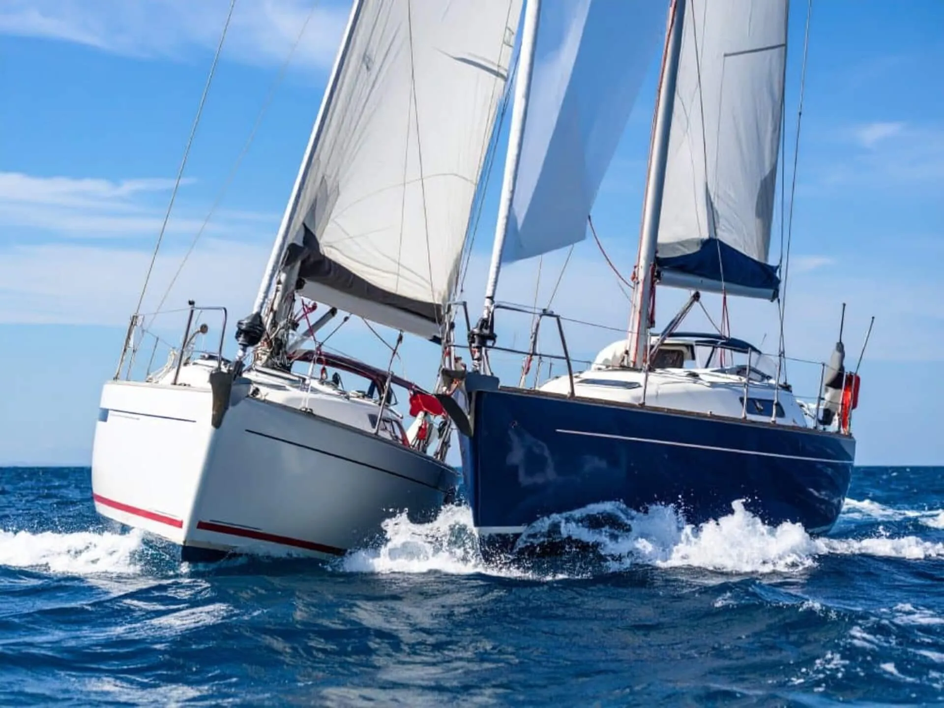 Two sailboats close together on open water.