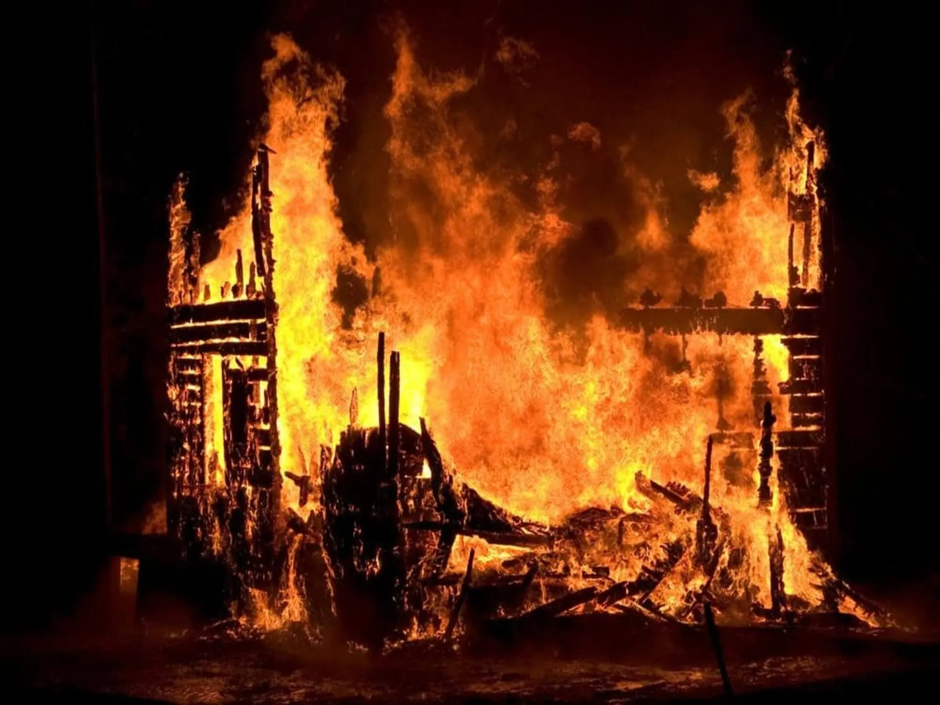 Flames and smoke rising from a building at night.