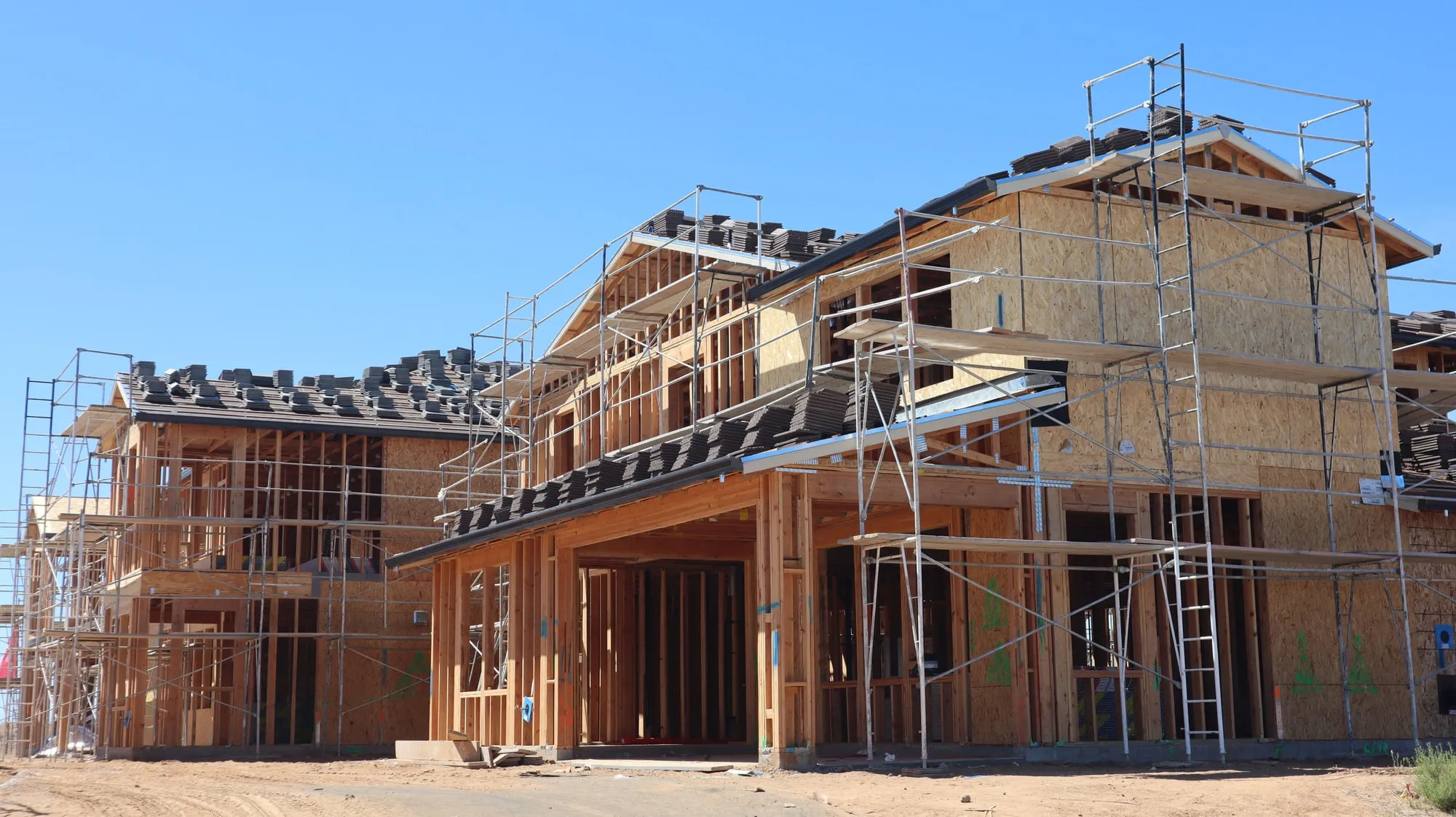 Scaffolding around houses under construction.