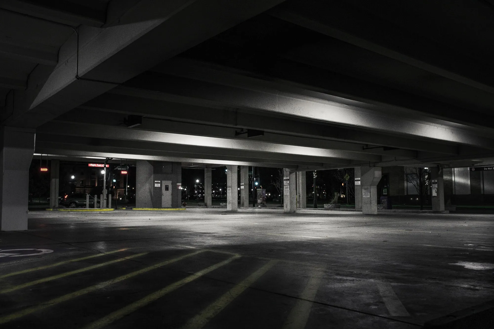An empty parking garage lit by overhead lights.
