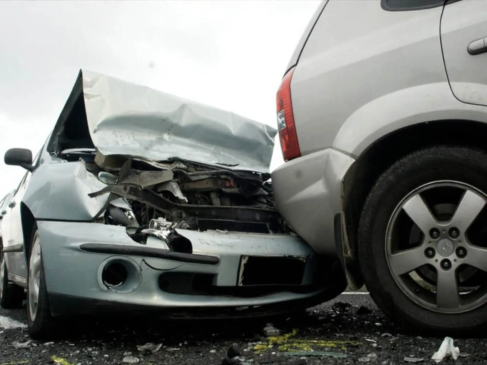 A car with a crumpled hood behind an SUV.